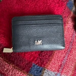 Michael kors black compact wallet in good condition lightly used .